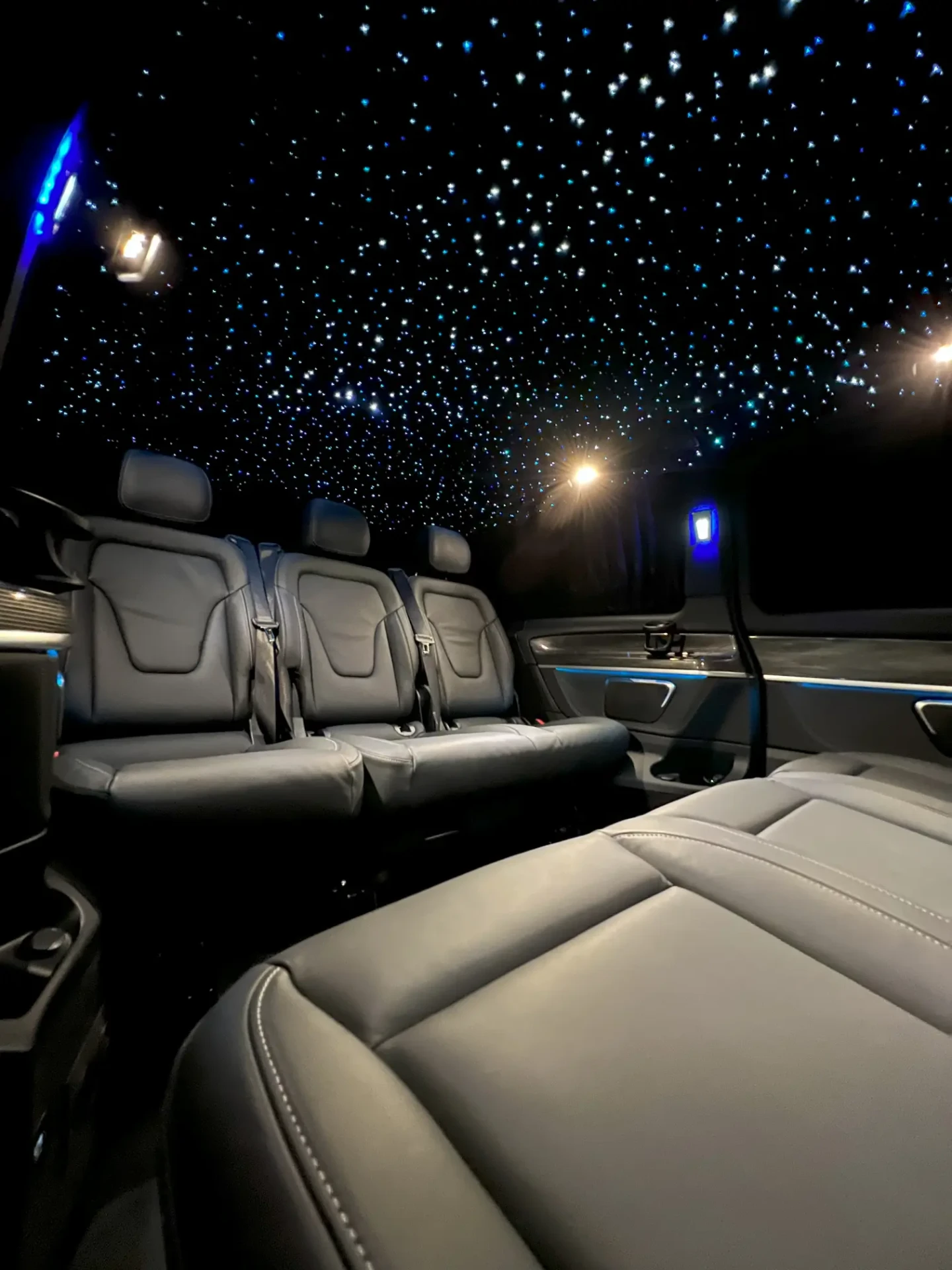 Habitacle arrière de la Mercedes Classe V DayNight Drive avec sièges en cuir et ciel étoilé bleu